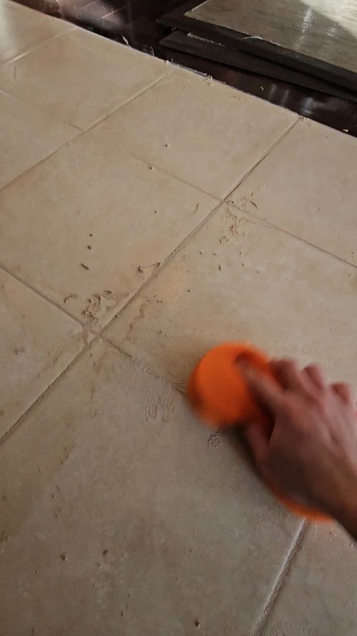 Applying new grout between floor tiles in Calgary home